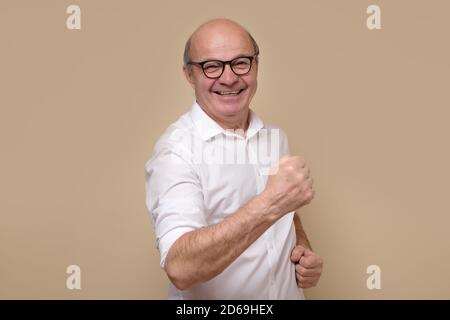 Senior man expressing his excitement and delight by shouting Yes Stock Photo