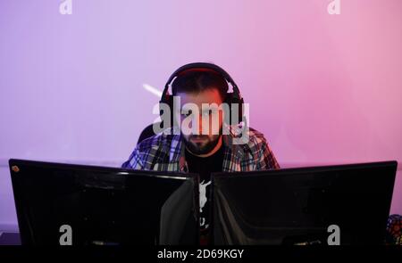 Portrait of young bearded pro gamer playing in online video game Stock Photo