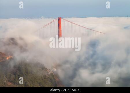 Lower fog blanket the San Francisco Bay at the Golden Gate Bridge in early autumnal evening, California, USA. Stock Photo