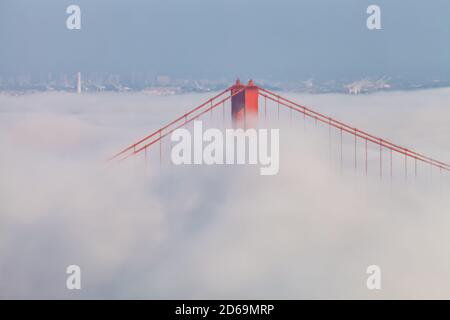 Close up at the Golden Gate Bridge as  lower fog blanket the San Francisco Bay  in early autumnal evening, California, USA. Stock Photo