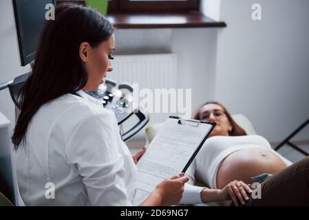 Female Doctor Sits In Clinic Cafe, Uses Laptop. Professional Medic 