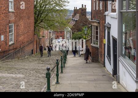 People walking on Steep Hill, an ancient medieval street in Lincoln, UK Stock Photo