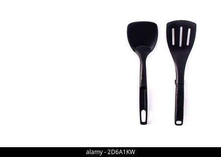 Black plastic kitchen spatula and spoon isolated on white background Stock Photo