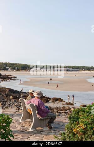 Men sitting and talking on a bench overlooking the beach along Marginal Way in Ogunquit, Maine, United States. Stock Photo