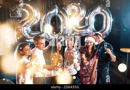 Positive young people holds balloons with new 2020 year and celebrating Stock Photo
