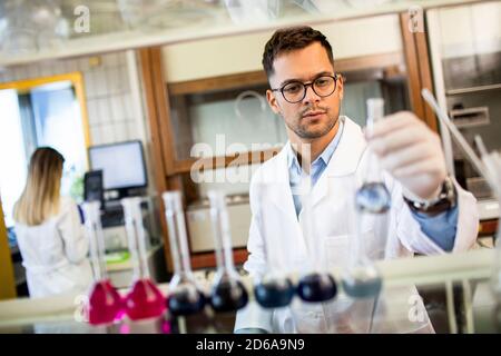 Young researcher checking test tubes in the laboratory Stock Photo