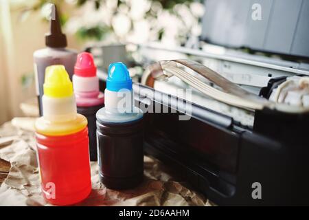 Refilling printer cartridges with multi-colored ink. Background Stock Photo