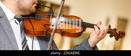 Playing violin, a musician plays vintage violin on a concert, close up Stock Photo