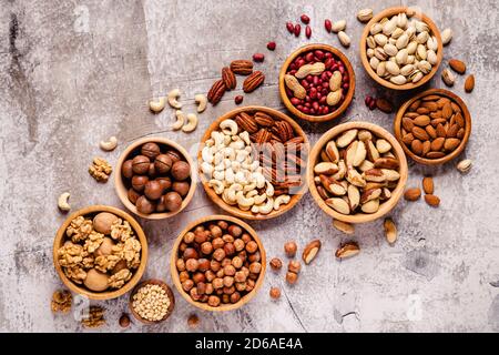 Various Nuts in wooden bowls, top view. Stock Photo