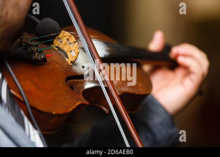 Playing violin, a man plays vintage violin on a concert, close up Stock Photo