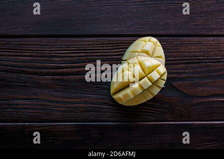 Mango halves. Two pieces of fresh mango fruit over wooden table Stock Photo