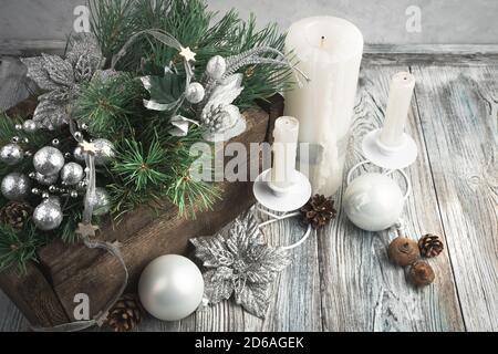 Christmas composition with candles, pine branches and festive decorations on a gray vintage background. Stock Photo