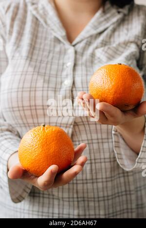 Woman holding two ripe oranges in her hands Stock Photo