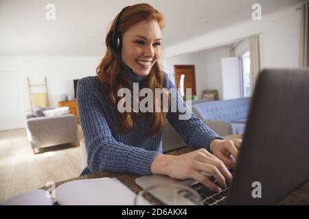 Woman wearing headset using laptop at home Stock Photo
