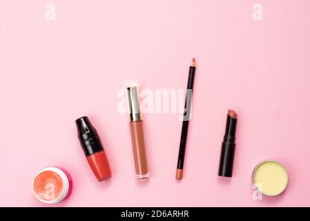 Lip balm, lipstick, gloss and pencil for lip contour on a pink background. Various lip products. Stock Photo