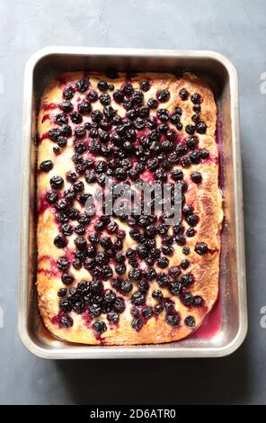 Homemade 'Schiacciata all'uva', typical Tuscan sweet focaccia with bread dough, olive oil, sugar, black grapes. Grey background, closeup. Stock Photo