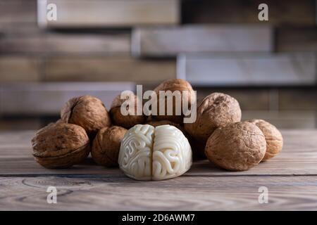 Walnuts like healthy food for the brain. Shape of human brain is surrounded by walnut kernels. It symbolizes how brain similarity with walnuts and Stock Photo