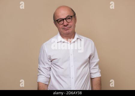 Senior man looking sadly at camera being tired. Stock Photo