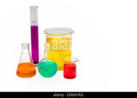 Laboratory glassware with liquids of different colors. Laboratory glassware with colored liquids on white background. Stock Photo