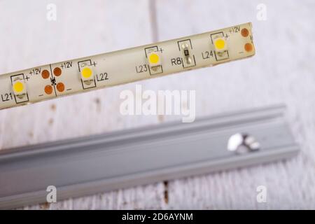 LED strip used to illuminate rooms in an aluminum strip. Electric accessories for self-assembly at home. Light background. Stock Photo