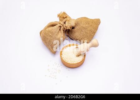 Assorted three types of rice isolated on white background. A traditional ingredient in healthy food preparation. Wooden scoop and handmade sacks Stock Photo