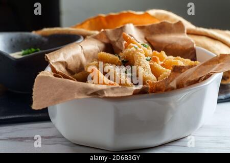 New England fried clam strips served with a bowl of tartar dipping sauce Stock Photo