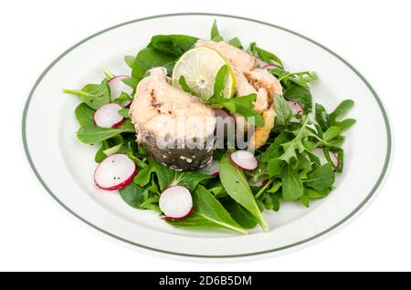 Canned fish with greens on plate isolated on white Stock Photo
