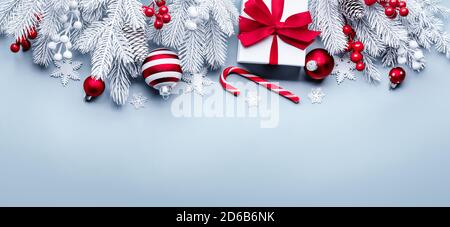 Gift box,red balls and spruce branch on light blue background Stock Photo
