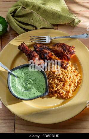 Peruvian chicken legs with aji verde green cilantro sauce and fried rice Stock Photo