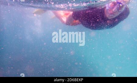 Great Keppel Island, Queensland, Australia - Dec 2019: Man snorkeling on a shallow coral reef in murky water cloudy due to wind and rain. Blurring of Stock Photo