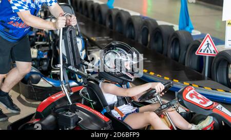 Mackay, Queensland, Australia - January 2020: A young girl drives a go-kart in a fun race around an indoor circuit Stock Photo