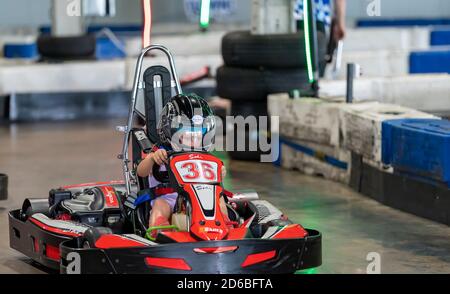 Mackay, Queensland, Australia - January 2020: A young girl drives a go-kart in a fun recreational drive around a circuit in public Stock Photo