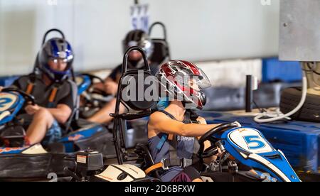 Mackay, Queensland, Australia - January 2020: A young woman rides a go-kart in a fun recreational drive around a circuit in public Stock Photo