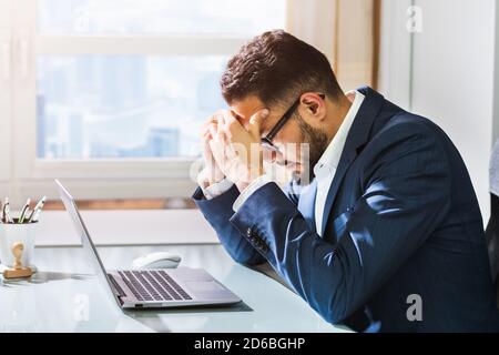 Unhappy Sad Man With Migraine Using Laptop Computer Stock Photo