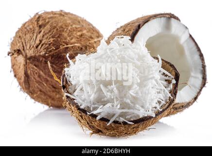 Coconut fruit and shredded coconut flakes in the piece of shell isolated on white background. Stock Photo