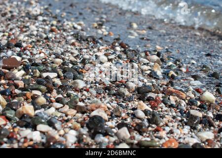 Colorful beach stones background. multi-colored pebbles on the beach, washed by waves. Abstract background. Stock Photo