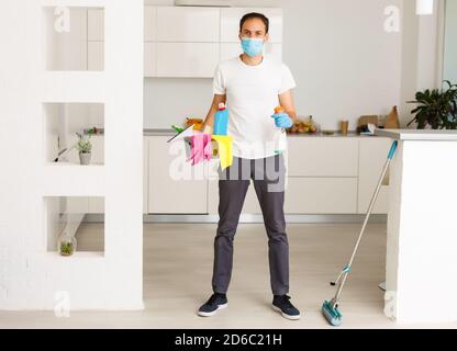 cleaning, health and hygiene concept - indian man wearing protective medical mask for protection from virus disease in gloves with detergent and mop