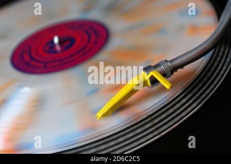 Colored vinyl on a record player with yellow pickup. Stock Photo