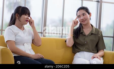 Two young Asian women practicing sign language at home Stock Photo