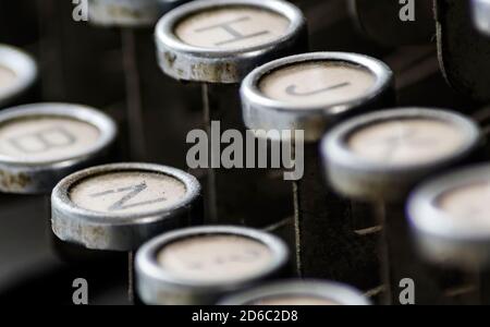 close-up of the dusty keys of an old typewriter. Shallow depth of field and selective focus. Mechanical writing tool used in the past by writers and j Stock Photo