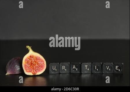 Idea Figurative made from Figs and Scrabble Tile Word on black table Stock Photo
