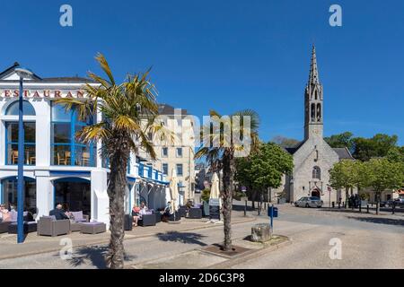 Benodet (Brittany, north-western France): cafe terraces along the quay quai du commandant l'Herminier. In the background, the Church of St. Thomas Bec Stock Photo