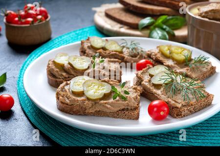 Canapes with chicken liver pate and pickled cucumbers on rye bread. Tasty and healthy appetizer Stock Photo