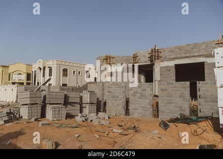 Construction site in the United Arab Emirates or similar concept with concrete shell and bricks in sand. Industrial concept. Stock Photo
