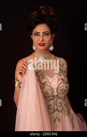 Indian model in pink and golden dress and jewelry. Looking away from camera  Stock Photo - Alamy