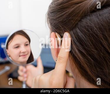 Advertising hearing aid for children, a caucasian race child showing a hearing aid behind the ear. Children's hearing treatment Stock Photo
