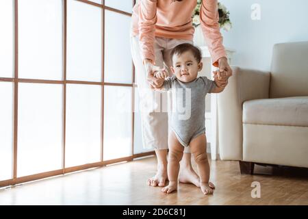 baby first step walking. mother help her baby to walk her first step at home Stock Photo Alamy