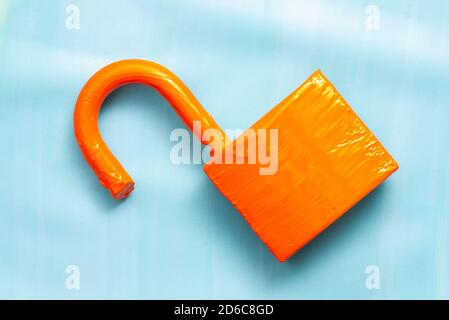 Orange padlock on blue background. Stock Photo
