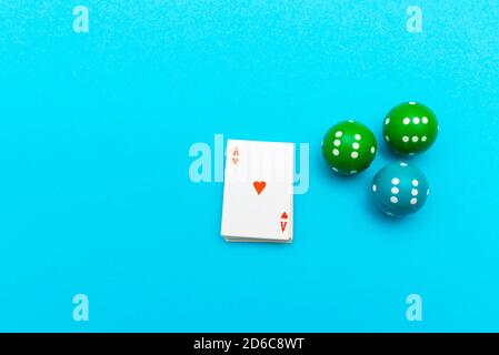 Ace of hearts and three dice lie on blue pastel background. Top view Stock Photo