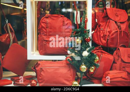 Istanbul, 25 December 2020: A New Year's decorated shop window with trendy red bags and backpacks. Time for Christmas or New Years sales. Stock Photo